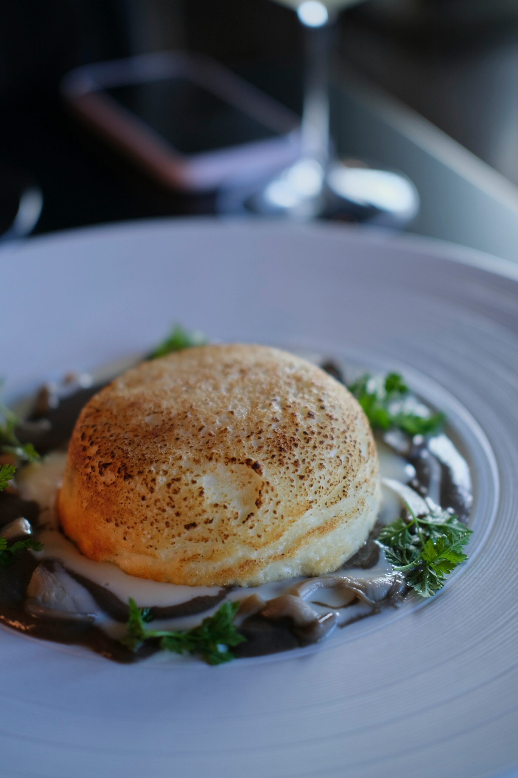 a white plate topped with food and a glass of wine