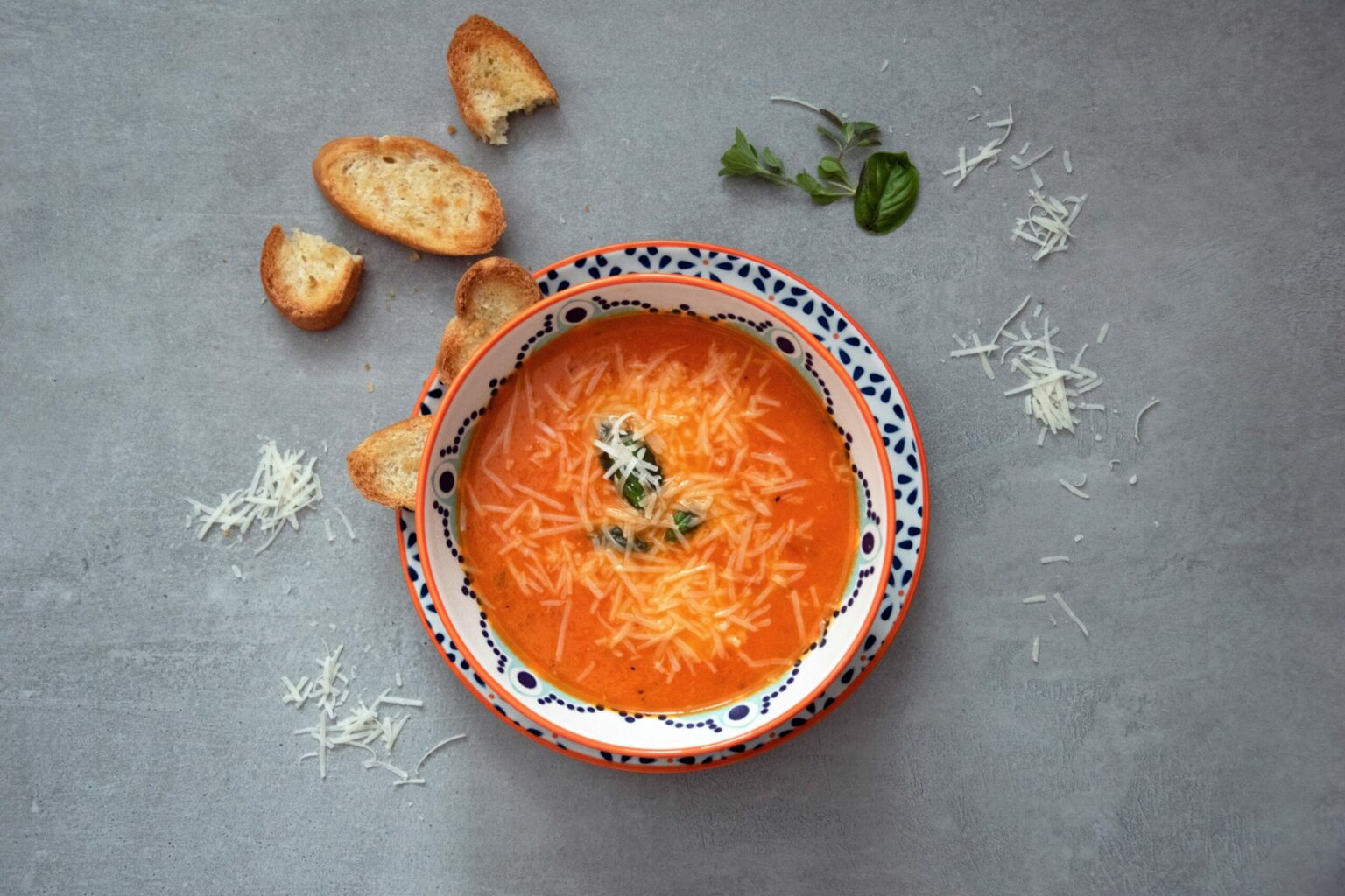 orange soup on white and blue ceramic bowl